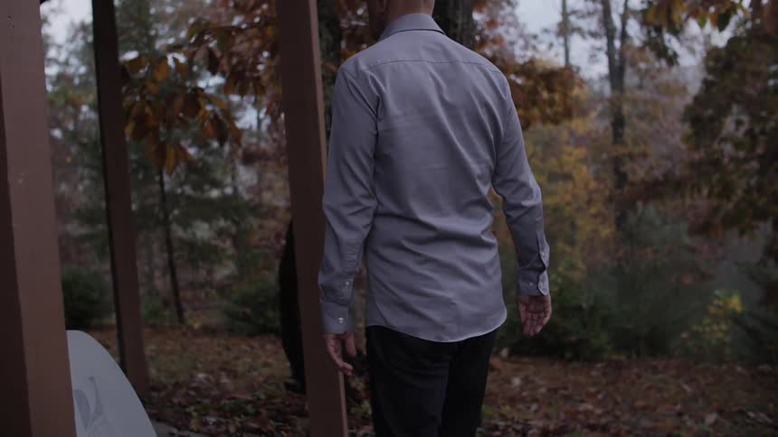 A man walks around the corner of a patio during the fall season