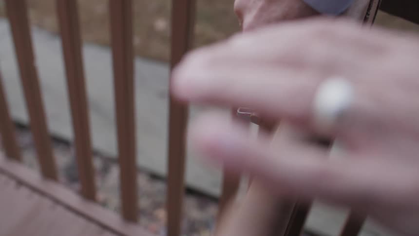 A man unlatches a lock on a gate