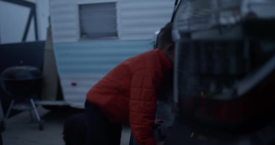 A person opens the trunk of an suv and a kid and a dog jump in the back