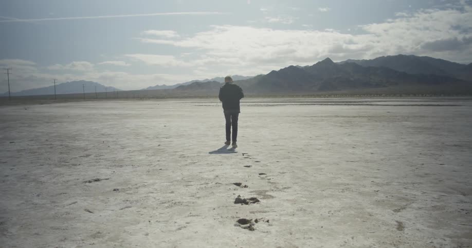 A man walks across a white field