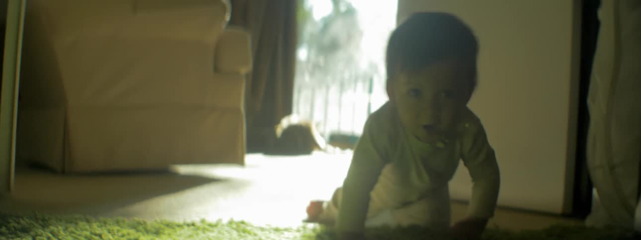 A baby crawls across the floor