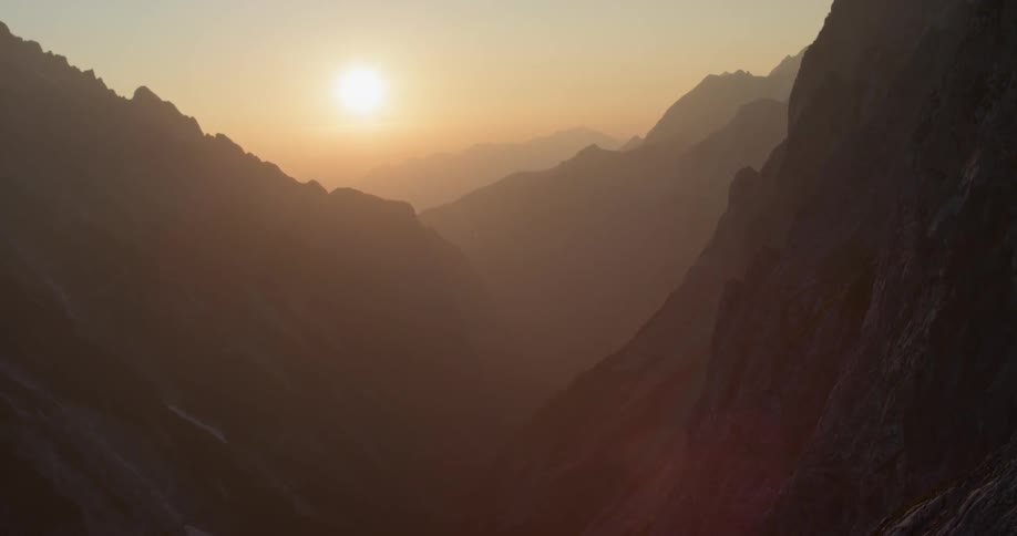 The sun is slowly rising behind the mountains