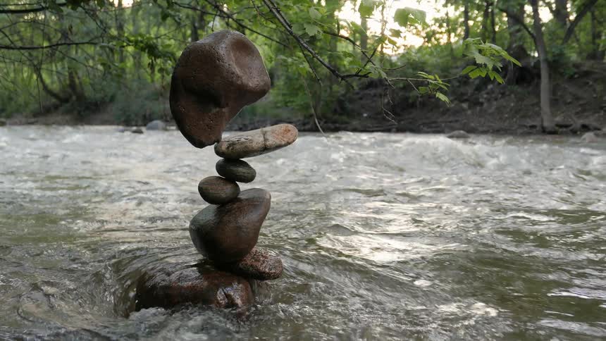 A stack of rocks balance in a running river