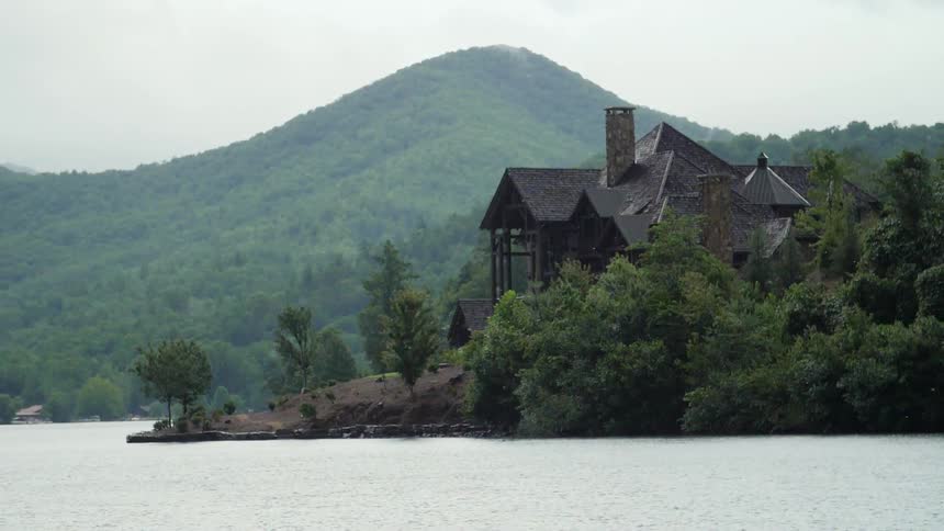 A house on a rocky hill near a lake