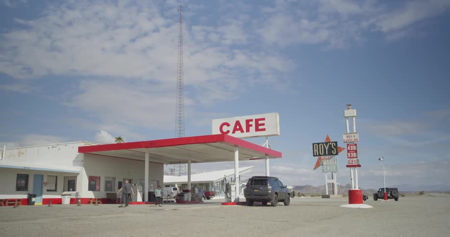 Two children play in front of a gas station