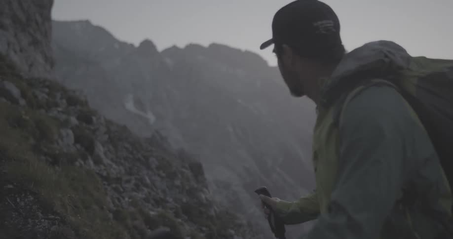 A man hikes in the mountains at sunset