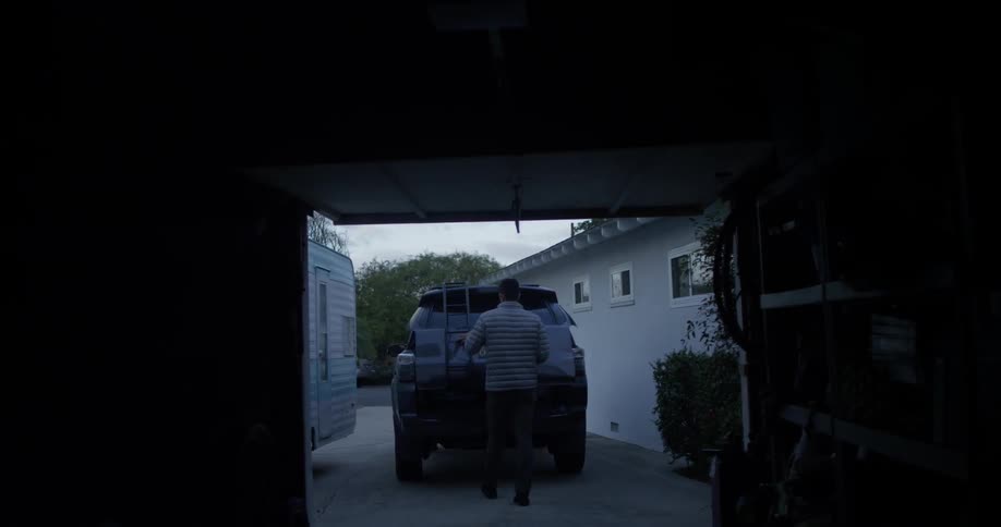 A man closes the trunk to his vehicle