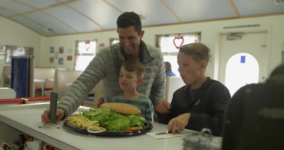 Man takes pictures of his kids eating a large burger