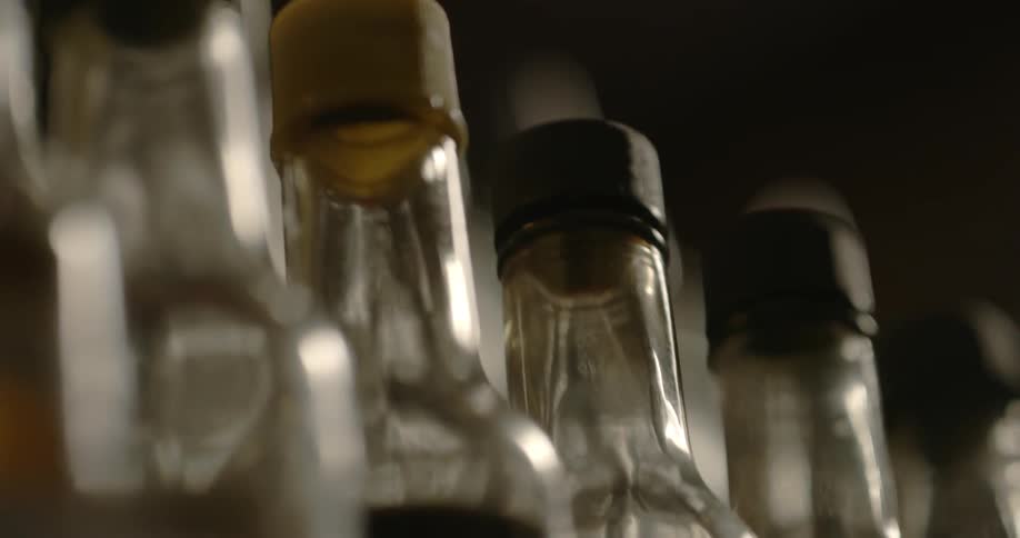 Glass bottles are lined up on a shelf