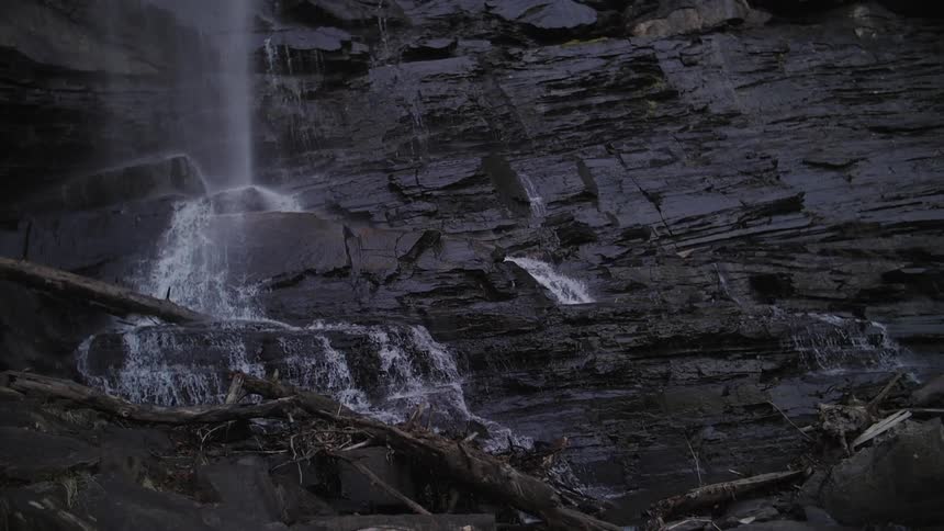 The water is pouring from the top of a cliff down the side