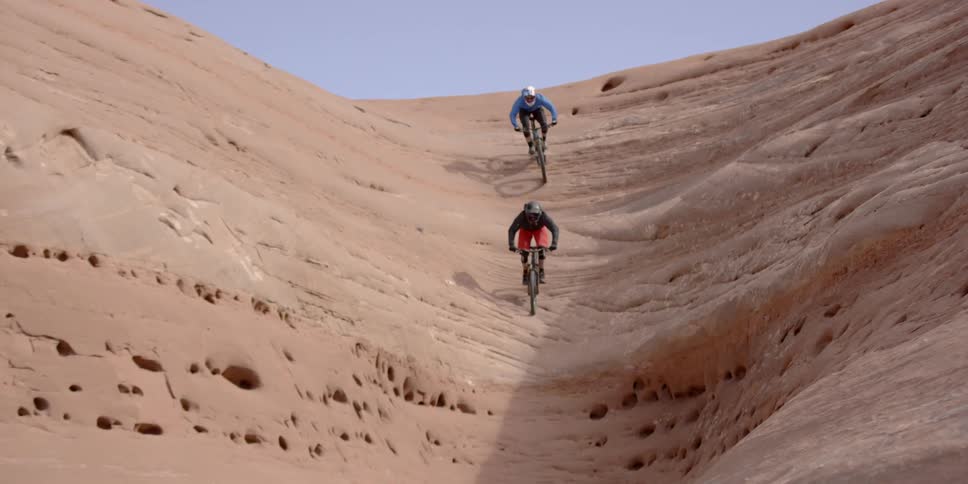 People ride their bikes down the side of a canyon