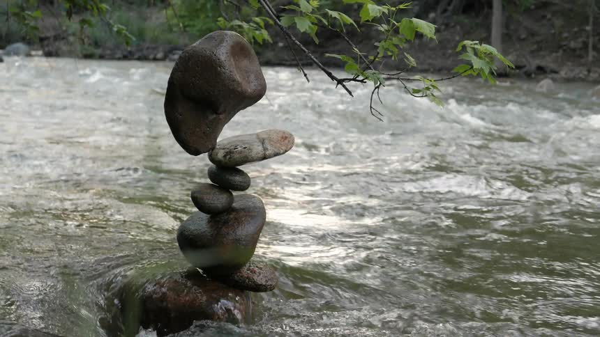 Water flowing around cairn in a river