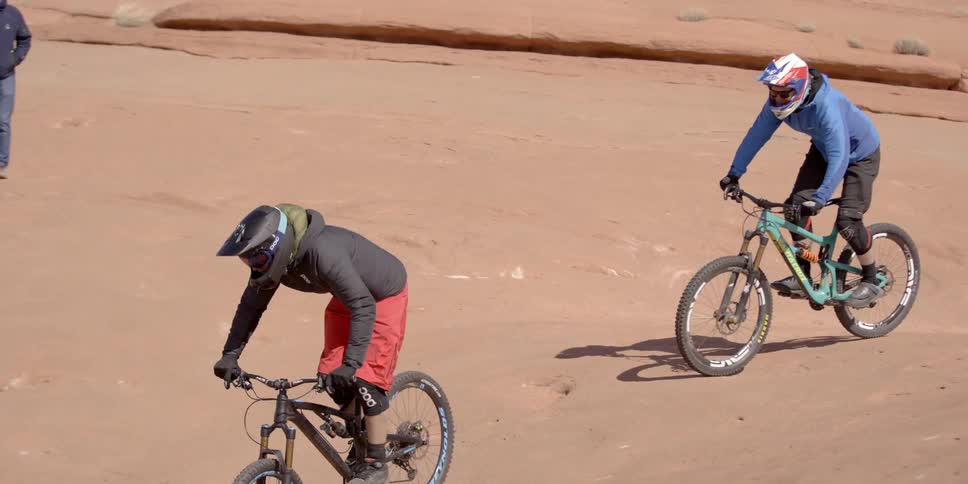 Two people riding bikes through the desert