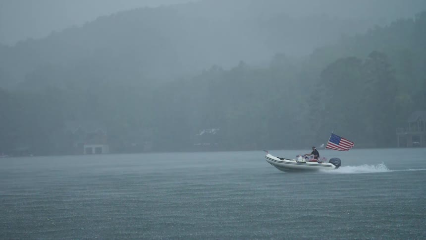 A boat travels over a foggy lake