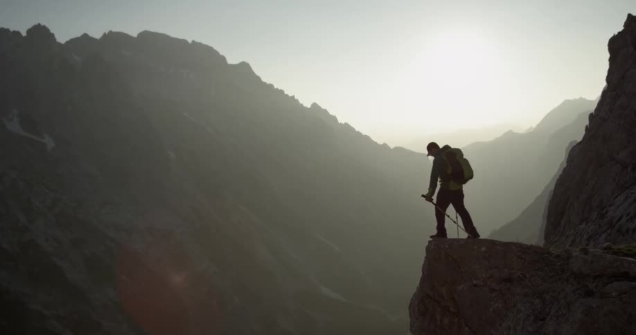 A man hikes up to a mountain edge