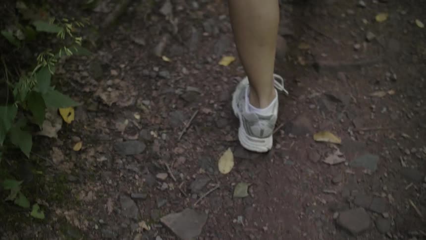 A woman hikes up a hiking trail