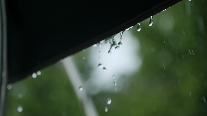 Raindrops drip from a rooftop