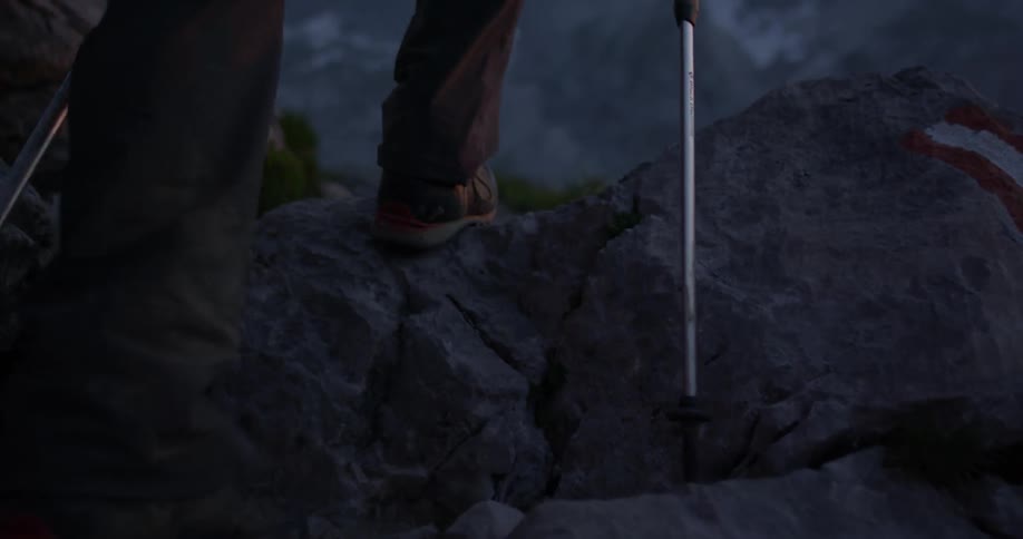 A man climbs a gravelly mountain path