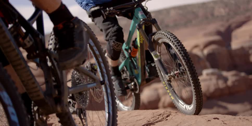 People ride bikes on an orange mountain