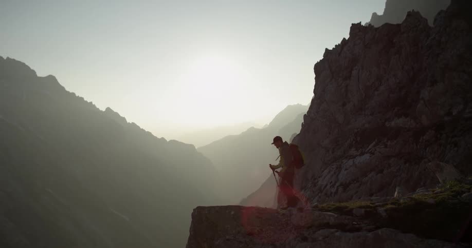 A hiker stands atop a cliff