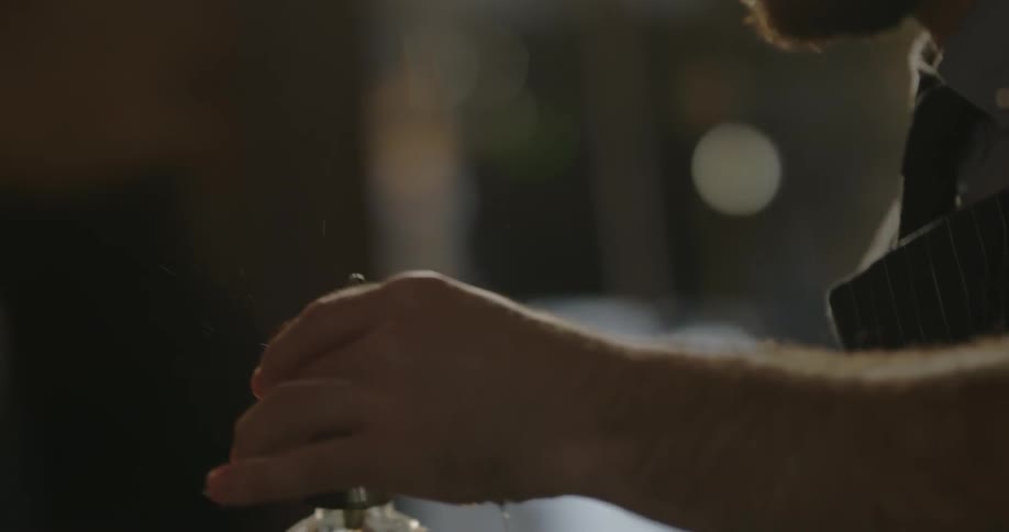 A man pours liquor into a shot glass