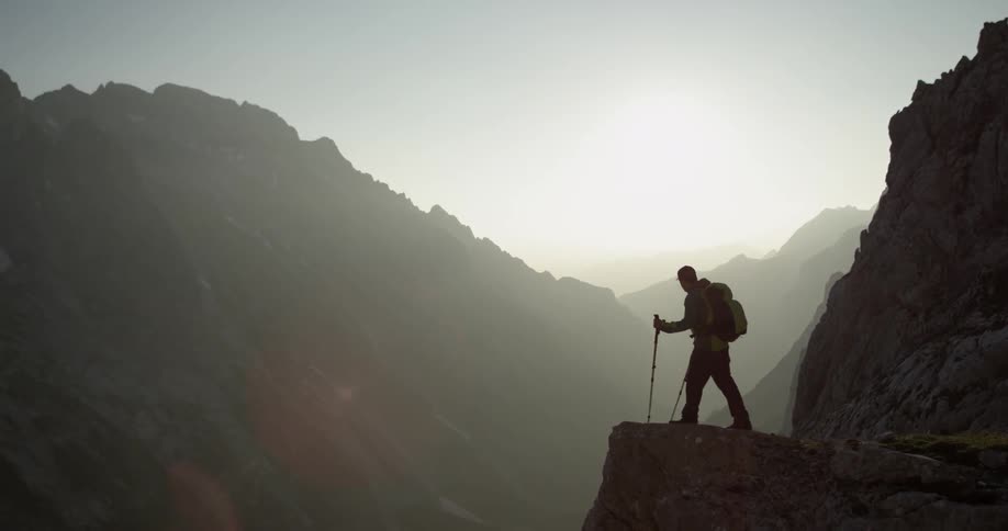 Person looks over the edge of a mountain