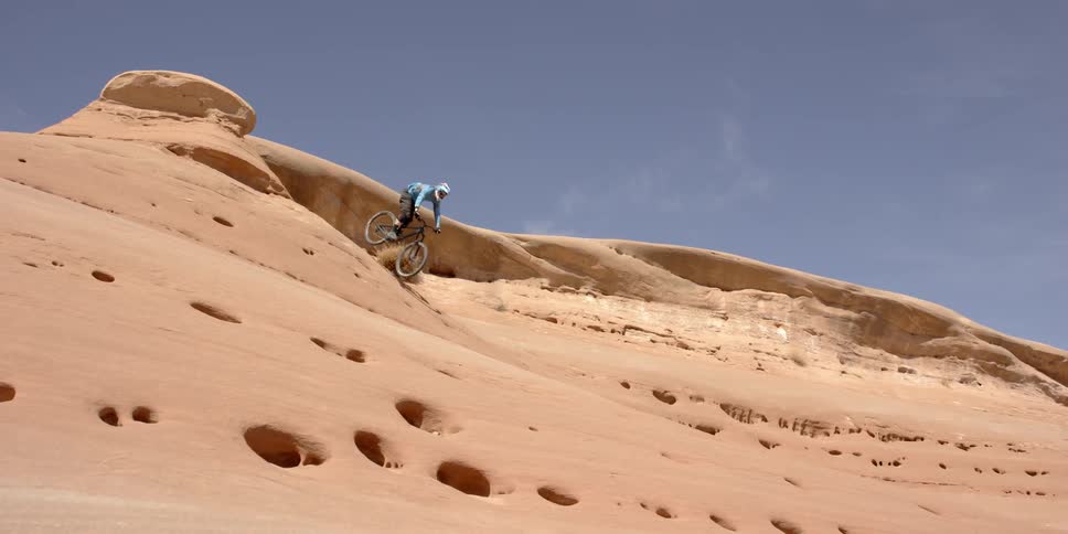 Person riding bike down a rocky cliff
