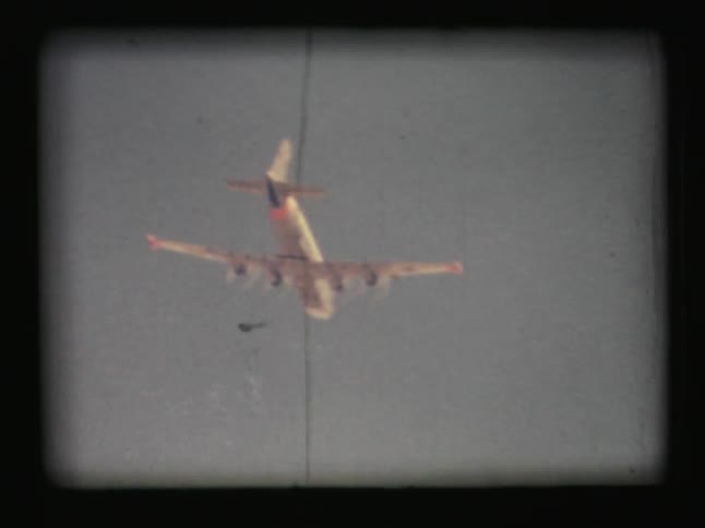 The underside of an airplane flying in a blue sky
