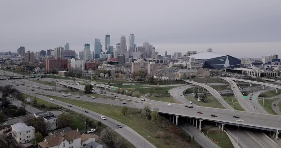 Traffic flows along a freeway in a city on an overcast day