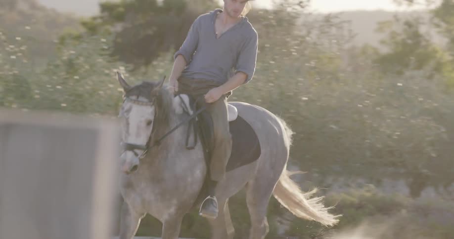 A man rides a horse at sunset
