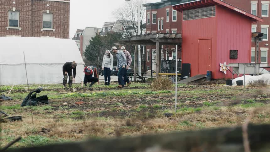 A group of people working in a grassy lot