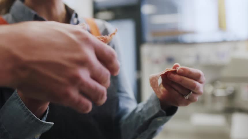 Workers share pieces of deli meat
