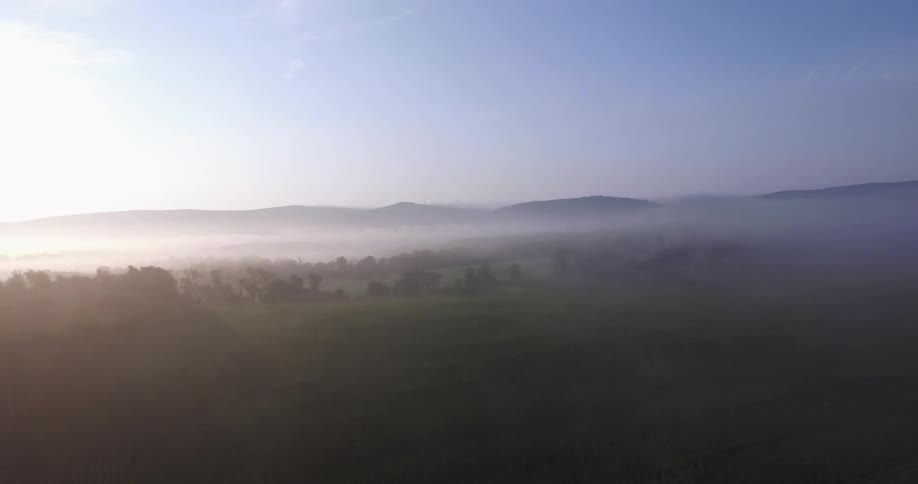 Darkness to a large foggy field with the sun rising
