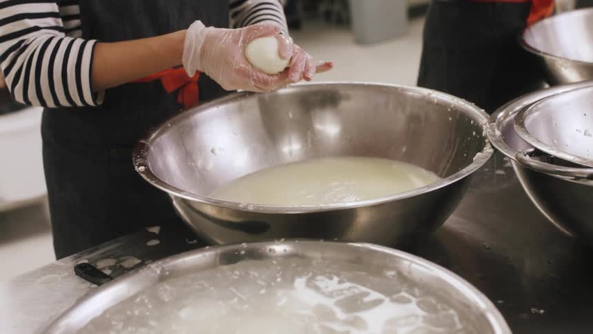 Woman squeezing some food into a bowl before placing it in another bowl that's filled with ice