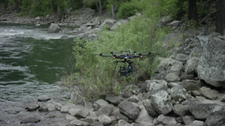 Drone flying over rapid waters and rocks