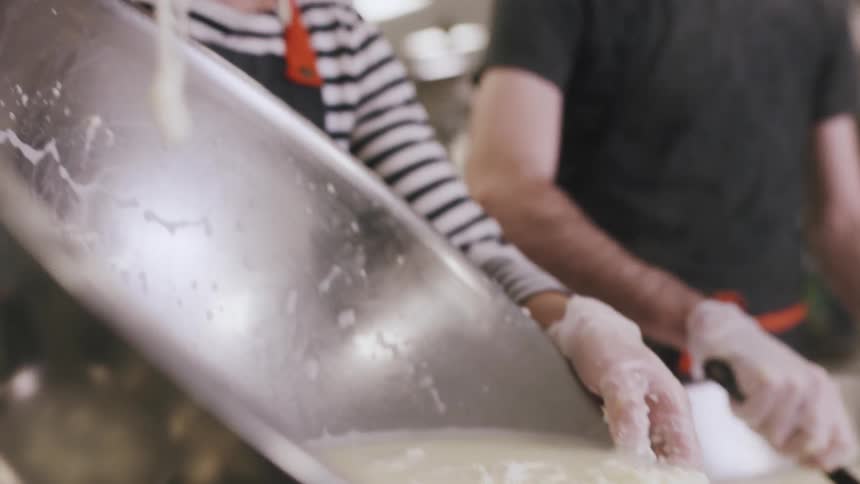 A woman pours a large bowl into a strainer