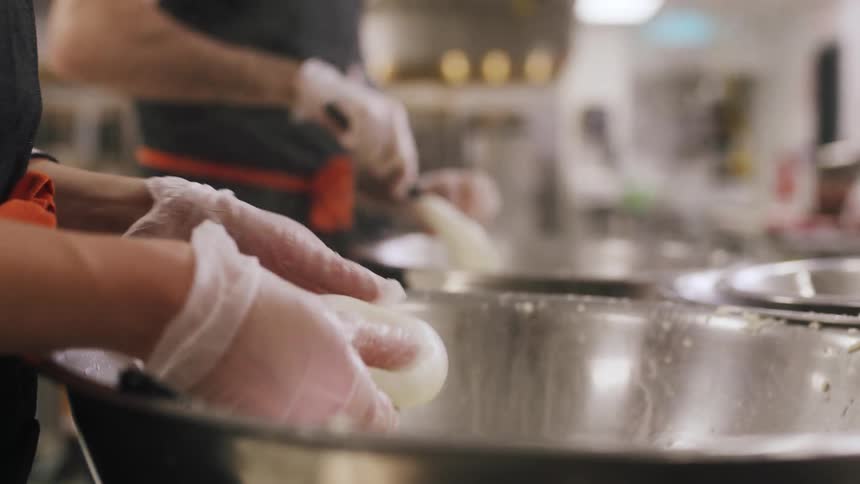 A woman rolls fresh cheese into a ball