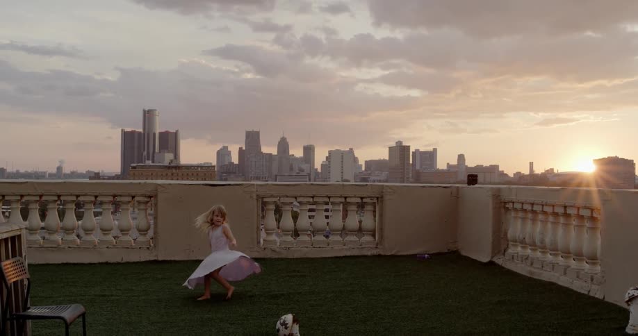 A child is playing on the roof at sunset