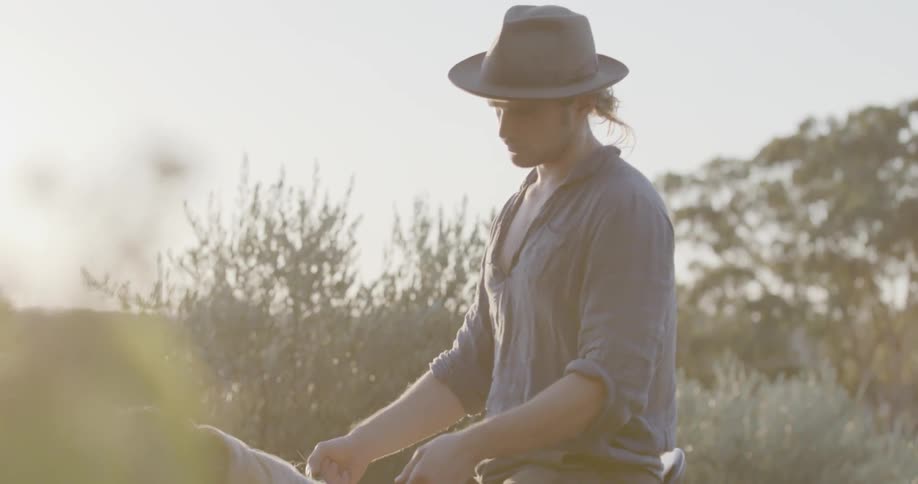 A man grabs the reigns of a horse while sitting atop