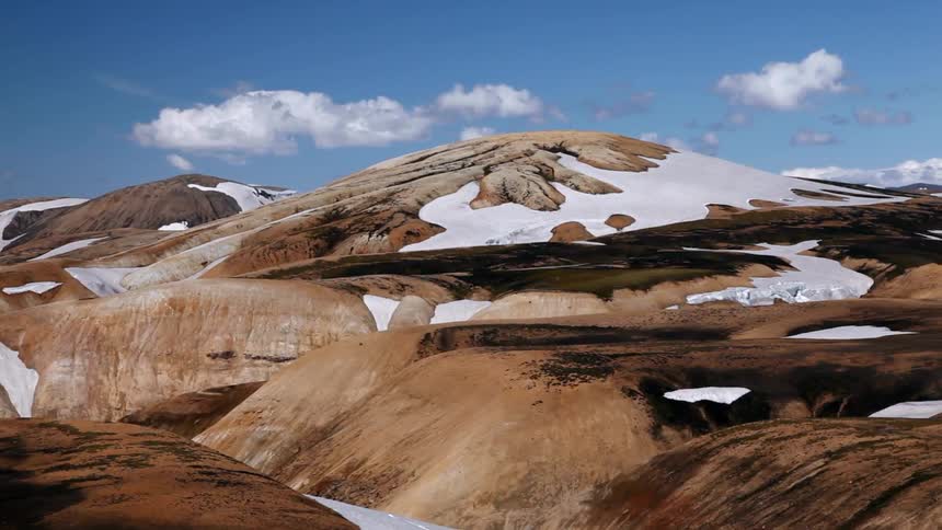The mountain range is covered with snow in spots