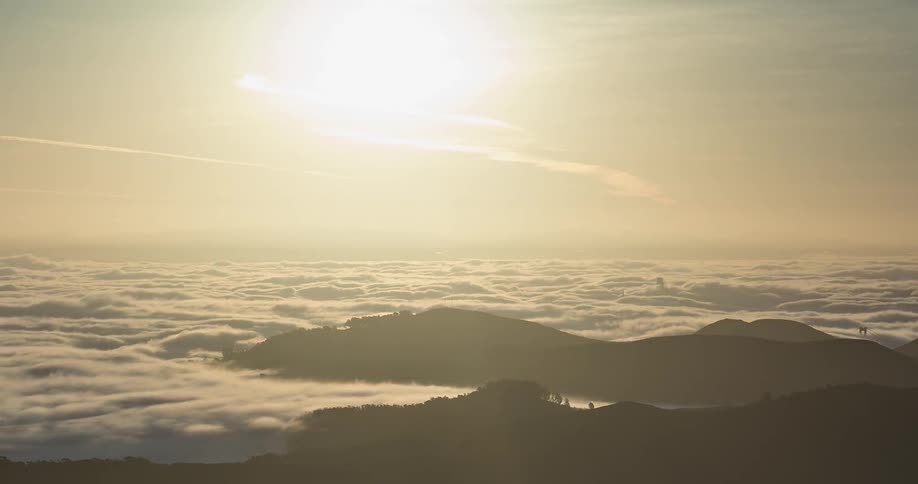 Clouds and fog roll across mountain tops during the day