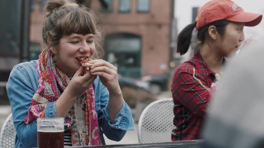 People sit down to eat pizza