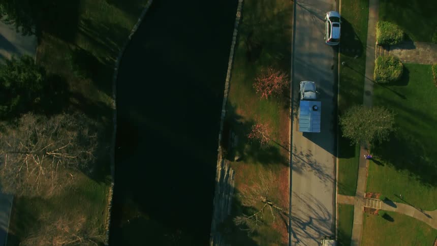 A large truck passes by a small street