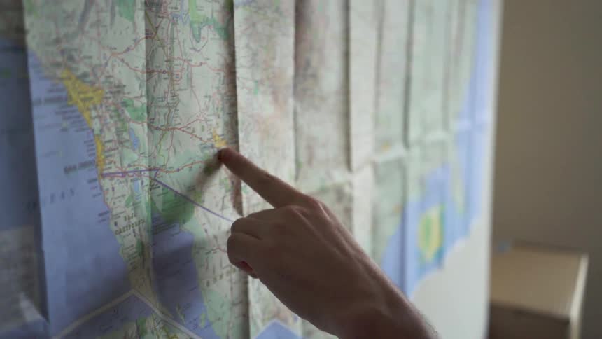 A finger traces a path on a map