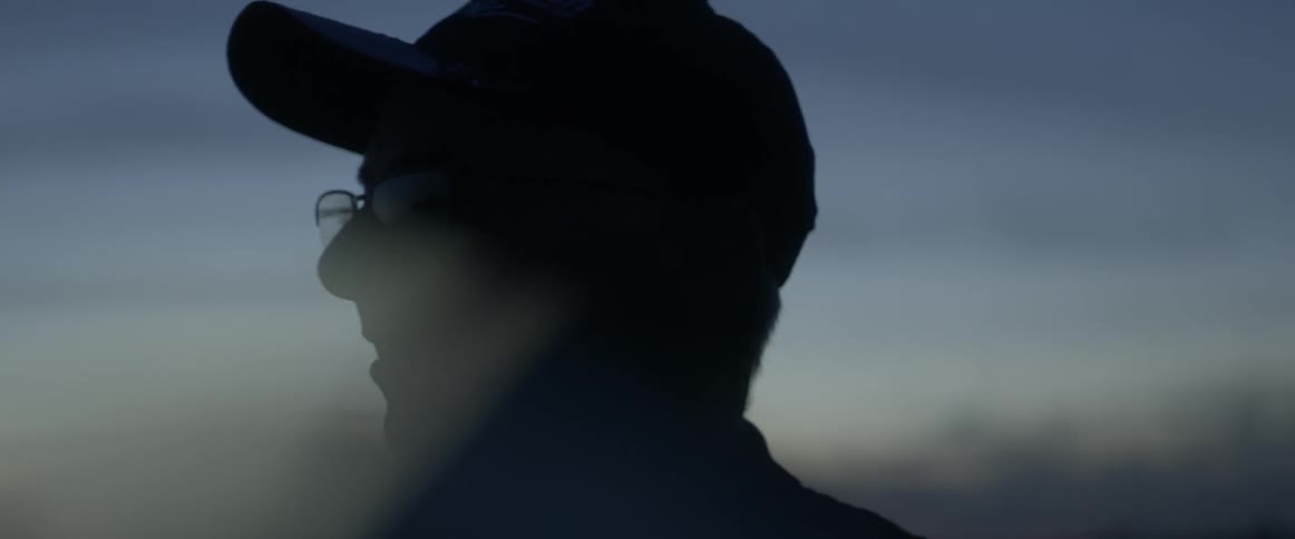 A man is smiling and looking at the sunset