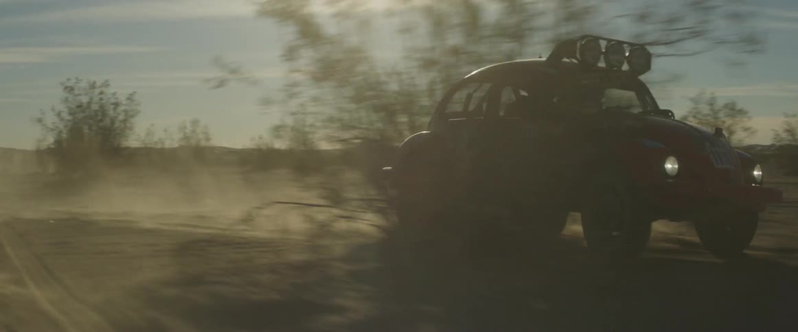 A vehicle races in the desert doing fast turns