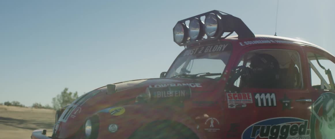 Racing volkswagen being driven across a dirt area