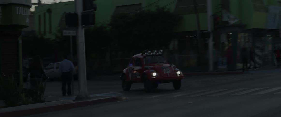 A car driving down an urban road at night