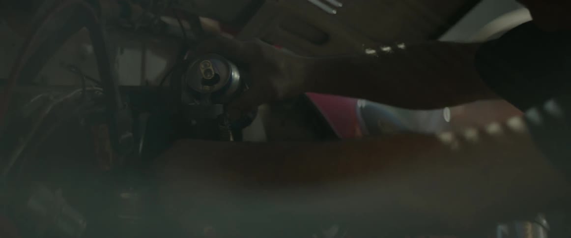 A person is working on a vehicle engine