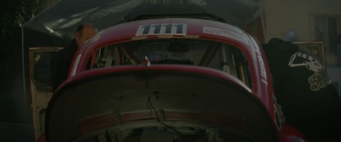 People work on a rally car in a garage